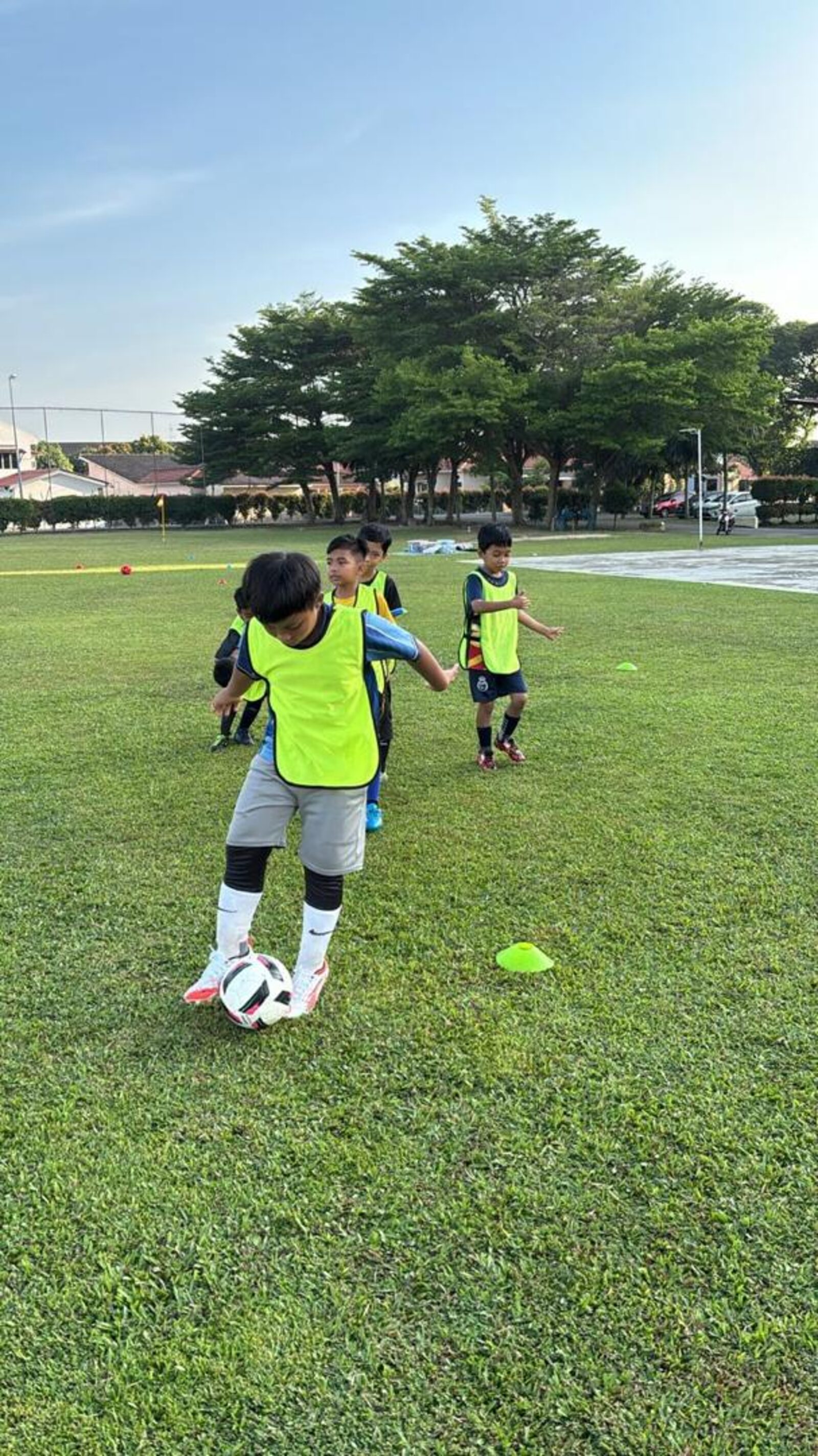 Pemain akademi menjalani latihan berpasukan di padang rumput